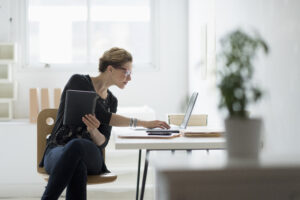 USA, New Jersey, Businesswoman using laptop in office