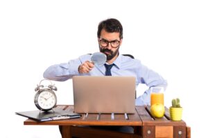 Businessman in his office with magnifying glass