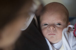 Six-month-old premature baby looks at the camera, eyes wide open