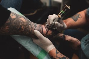 tattooist-tattooing-young-mans-arm-close-up-royalty-free-image-1642089038
