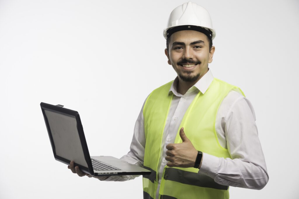 Engineer in uniform holding a laptop and making thumb up